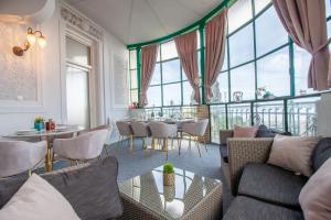 Villa Muenz Luxurious Residence في بولا: غرفة معيشة مع أريكة وطاولات ونوافذ