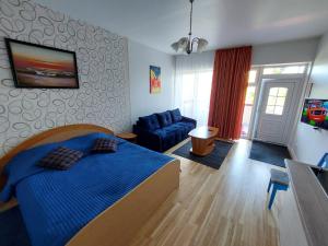 una camera con un letto blu e un divano blu di Holiday Palanga a Palanga