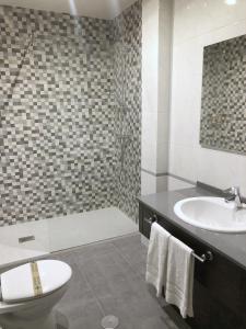 a bathroom with a sink and a toilet and a tub at Hotel As Hortensias in Corcubión