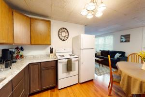 a kitchen with a white refrigerator and a table at Lake Den in Vassalboro
