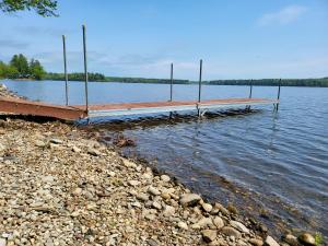 a dock on a body of water next to the shore at Lake Den in Vassalboro