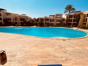 una grande piscina blu di fronte ad alcuni edifici di Sea View Apartment at Tala Bay Resort in Aqaba ad Aqaba