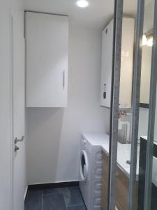 a washing machine in a bathroom with a mirror at Superbe logement proche de CDG- Parc d'expo- Paris in Aulnay-sous-Bois