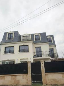 een groot wit huis met een zwart dak bij Superbe logement proche de CDG- Parc d'expo- Paris in Aulnay-sous-Bois