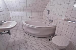 a bathroom with a tub and a toilet and a sink at Parkhotel Wörlitz in Oranienbaum-Wörlitz +15 photos