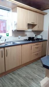 a kitchen with wooden cabinets and a black counter top at Beeston House in Thornton