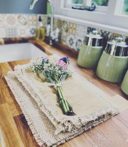 a bunch of flowers on a cutting board on a kitchen counter at Jasmine The Shepherd Hut in Woodhall Spa
