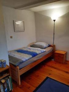 niewielka sypialnia z łóżkiem i lampką w obiekcie Wohnen im Fachwerkhof w mieście Kassel