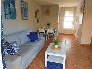 sala de estar con sofá y mesa en Bonito apartamento con jardín privado en Novo, en Novo Sancti Petri