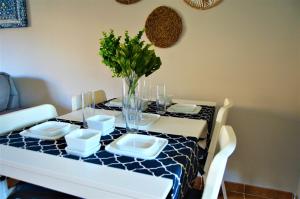 mesa de comedor con mantel azul y blanco en Bonito apartamento con jardín privado en Novo en Novo Sancti Petri