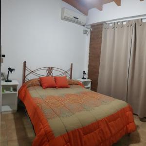 Un dormitorio con una cama con almohadas rojas. en Kupal Departamentos en San Juan