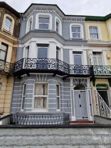 a blue house with a balcony on a street at SEA VIEW STAY 17 Princes Road in Great Yarmouth