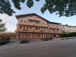 un edificio con balcones al lado de una calle en Hotel Ristorante Pennar, en Asiago