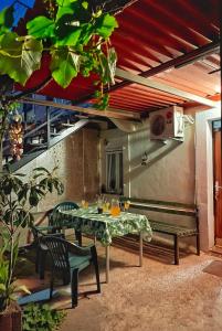 a patio with a table and chairs and a bench at 1-bedroom apartment with 3 beds + private parking in Tivat