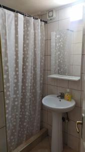 a bathroom with a shower curtain and a sink at 1-bedroom apartment with 3 beds + private parking in Tivat