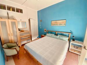 1 dormitorio azul con 1 cama y 1 silla en CasaAzul, en Sperlonga