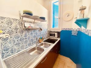 cocina con fregadero y pared de azulejos azules en CasaAzul, en Sperlonga