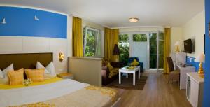 um quarto de hotel com uma cama e uma sala de estar em Hotel Garni Inselparadies Zingst em Zingst