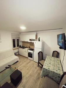 a room with a bed and a table and a kitchen at 1-bedroom apartment with 3 beds + private parking in Tivat +4 photos