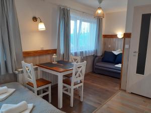 a room with a table and chairs and a couch at Apartamenty nad Jeziorem in Międzybrodzie Żywieckie