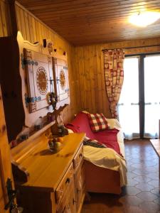 a small bedroom with a bed and a desk in it at Accogliente appartamento in centro Champoluc in Champoluc