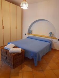 Casa Mandarino Forio Ischia في ايسكيا: غرفة نوم بسرير وسلة ومصباح