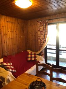 a living room with a red couch and a table at Accogliente appartamento in centro Champoluc in Champoluc
