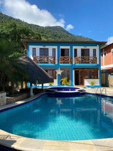 una casa con piscina frente a una casa en Pousada do Canto en Ilha Grande