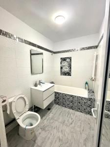 a bathroom with a toilet and a sink and a tub at Residence RMZ in Mangalia