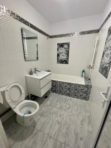 a bathroom with a toilet and a tub and a sink at Residence RMZ in Mangalia