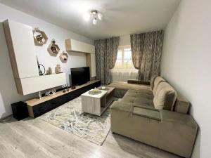 a living room with a couch and a tv at Residence RMZ in Mangalia
