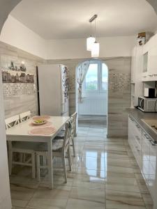 a kitchen with a table and a white refrigerator at Residence RMZ in Mangalia