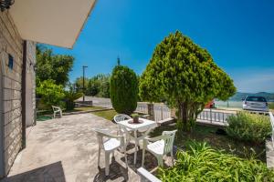 un patio con mesa, sillas y un árbol en Village apartments Mimi, en Pridvorje
