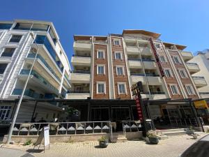 a tall building on a street with two buildings at Baskent Otel in Didim