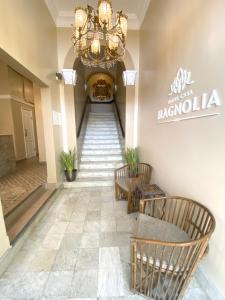 a hallway with stairs with chairs and a chandelier at Magnolia Inn in Panama City
