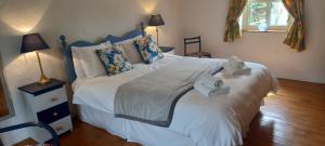 a bedroom with a large white bed with towels on it at Cheerful Cottage in Westport +10 photos
