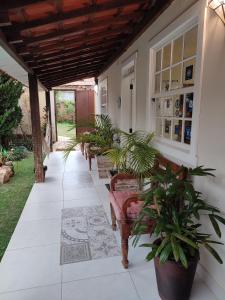 a porch with a row of benches and plants at Pousada Abelha Rainha in Tiradentes