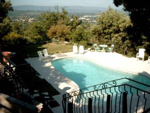a swimming pool in a yard with chairs around it at PROVENCE SOLEIL LUBERON PISCINE in Apt