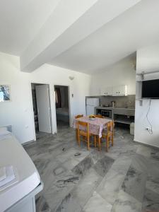 a kitchen with a table and chairs in a room at Country House Apartments in Ios Chora