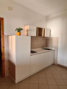 a kitchen with white cabinets and a counter top at Villa Nausica in Capo Vaticano