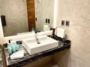 y baño con lavabo blanco y espejo. en Condesa Lives, en Ciudad de México