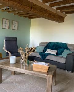 sala de estar con sofá y mesa de centro en Les Clématites, maison de campagne. en Boissy-lès-Perche