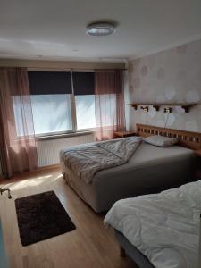 a bedroom with two beds and a window at Sun in Närpiö