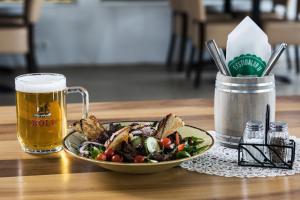 einen Teller mit Essen und ein Glas Bier auf dem Tisch in der Unterkunft Farmhotel Efstidalur in Laugarvatn
