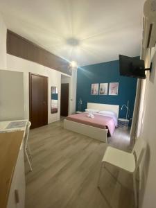 sypialnia z różowym łóżkiem i niebieską ścianą w obiekcie Home Demetra w mieście Agrigento