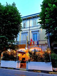 Biały budynek z flagami z przodu w obiekcie Hotel Tahiti w Viareggio