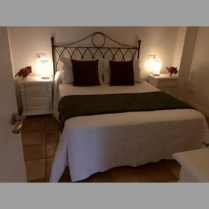 1 dormitorio con 1 cama grande y 2 mesitas de noche en Puente Romano, en Galizano