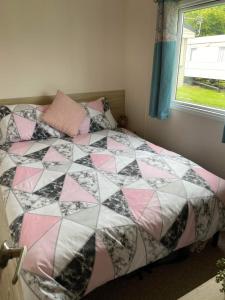 a bedroom with a bed with a quilt on it at 32 Elm Walk in Whitley Bay