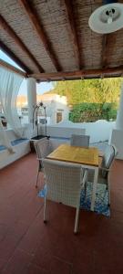 a wooden table and chairs on a patio at La Casa al Mare Vulcano in Vulcano
