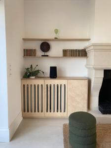 un soggiorno con termosifone in legno e sedia di La Source - Villa wissantaise a Wissant